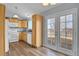 Cozy kitchen with wood cabinets, white appliances, laminate flooring, and bright French patio doors at 270 N Holcomb Cir, Castle Rock, CO 80104