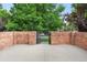 The brick walled front yard with an iron gate that provides privacy and street access at 538 Cook St, Denver, CO 80206