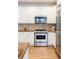 Well-lit kitchen features white cabinets, a stainless steel oven and microwave, and hardwood floors at 538 Cook St, Denver, CO 80206