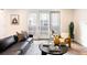 Cozy living room with a black sofa, yellow chair, decorative pillows, and sliding glass doors at 538 Cook St, Denver, CO 80206