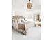 Well-lit main bedroom with a woven chandelier, neutral colors, and minimalist artwork at 538 Cook St, Denver, CO 80206