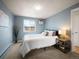 Comfortable bedroom with soft blue walls, plush carpet, and a well-lit window at 155 S Pennsylvania St # 310, Denver, CO 80209