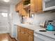 Efficient kitchen featuring wooden cabinets and a white appliance suite with access to the bathroom at 155 S Pennsylvania St # 310, Denver, CO 80209