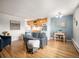 Bright living room featuring hardwood floors, a comfortable gray sofa and an adjacent dining space at 155 S Pennsylvania St # 310, Denver, CO 80209