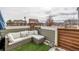 Cozy outdoor deck with synthetic turf and a white wicker sectional couch at 12888 Jasmine St # F, Thornton, CO 80602