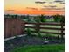 Scenic backyard view at sunset with a wooden fence and landscaping, and a peek of other neighborhood houses at 21 N Edge Cliff St, Castle Rock, CO 80104