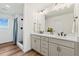 Ensuite bathroom featuring a dual sink vanity with modern lighting and a tiled walk-in shower at 21 N Edge Cliff St, Castle Rock, CO 80104