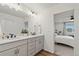 Ensuite bathroom features a dual sink vanity, modern lighting, and wood-look flooring at 21 N Edge Cliff St, Castle Rock, CO 80104