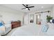 Bright bedroom with ceiling fan, light-colored carpet, accent chair, and access to ensuite bathroom at 21 N Edge Cliff St, Castle Rock, CO 80104