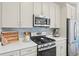 Modern kitchen features stainless steel appliances, grey cabinetry, and light countertops at 21 N Edge Cliff St, Castle Rock, CO 80104
