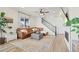 Inviting living room with a cozy brown leather sectional, decorative rug, and adjacent staircase at 21 N Edge Cliff St, Castle Rock, CO 80104
