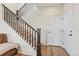 Well-lit staircase featuring carpeted steps, dark wood railings, and a landing with doors at 21 N Edge Cliff St, Castle Rock, CO 80104