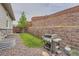 Well-maintained backyard with retaining wall, lush grass, and a barbecue grill at 8153 S Ider Ct, Aurora, CO 80016