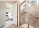 Shower with glass door, gray tiling and showerhead; door opens up to view the Primary bedroom at 8153 S Ider Ct, Aurora, CO 80016