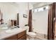 Bathroom featuring a shower and bath, toilet, sink with counter and window with plants at 8153 S Ider Ct, Aurora, CO 80016