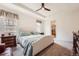 Bedroom showcases a tray ceiling, ceiling fan, ensuite bathroom, and windows letting in natural light at 8153 S Ider Ct, Aurora, CO 80016