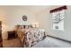 Cozy bedroom with neutral walls, carpet flooring, a vintage nightstand and a window at 8153 S Ider Ct, Aurora, CO 80016