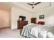 Comfortable bedroom features an entertainment center, TV, ceiling fan, and neutral colored walls at 8153 S Ider Ct, Aurora, CO 80016