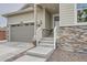 Close-up of front of house showing stone accents, gray siding, an inviting front porch and stairs to the front door at 8153 S Ider Ct, Aurora, CO 80016