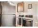 Convenient laundry room featuring modern washer, dryer, storage, and stainless steel refrigerator at 8153 S Ider Ct, Aurora, CO 80016