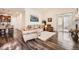 Bright living room featuring hardwood floors, comfortable seating, vaulted ceilings, and sliding doors to an outdoor patio at 8153 S Ider Ct, Aurora, CO 80016