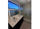 Modern bathroom featuring a double vanity, large mirror, and a glass-enclosed shower at 1252 Yates St, Denver, CO 80204