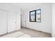 Bright bedroom featuring neutral carpet, closet with sliding doors, doorway and an exterior view through the window at 1252 Yates St, Denver, CO 80204