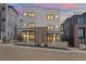 Contemporary townhome with a modern facade, clean lines, and a landscaped front yard under a colorful dusk sky at 1252 Yates St, Denver, CO 80204