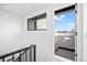 Staircase landing with a door to an outdoor deck. The interior features white walls and black railings at 1252 Yates St, Denver, CO 80204