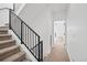 Carpeted stairs with a modern black metal railing lead to an upstairs hallway, bright with natural light at 1252 Yates St, Denver, CO 80204