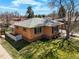 Overhead view of a brick home featuring a well-maintained lawn and mature trees at 2562 S Xavier St, Denver, CO 80219