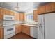 Traditional kitchen features wood cabinets, white appliances, hardwood floors, and bright, natural light at 2562 S Xavier St, Denver, CO 80219