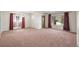Spacious living room features plush carpeting, large windows, and a decorative chandelier at 2562 S Xavier St, Denver, CO 80219