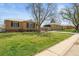 Quaint street view showcases the brick house with a spacious front yard in a residential neighborhood at 2562 S Xavier St, Denver, CO 80219