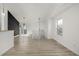 Bright living area with hardwood floors, leading to the stairway and glass patio doors at 17486 E Plateau Dr, Aurora, CO 80015