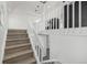 View of the staircase with wood stairs and white railings, leading to a lower level at 17486 E Plateau Dr, Aurora, CO 80015