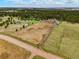 Expansive aerial view of property featuring a residence, outbuildings, and surrounding treed landscape at 37625 Pheasant Run, Elizabeth, CO 80107