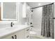 Clean bathroom with marble wall tile, vanity with black hardware, and shower with snowflake curtain at 37625 Pheasant Run, Elizabeth, CO 80107