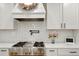 Modern kitchen boasts stainless steel stove, white cabinetry, and subway tile backsplash at 37625 Pheasant Run, Elizabeth, CO 80107
