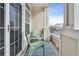 Cozy balcony featuring two green chairs, striped rug, and view of neighboring homes at 9733 E Carolina Pl, Aurora, CO 80247