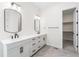 This bathroom features a dual sink vanity, modern fixtures, and a walk in closet at 7392 Timberstone St, Castle Pines, CO 80108