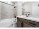 Modern bathroom featuring a tub with tiled shower, white vanity and marble countertop at 7392 Timberstone St, Castle Pines, CO 80108