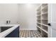 Laundry room with patterned tile flooring, wash sink and shelving at 7392 Timberstone St, Castle Pines, CO 80108
