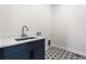 This laundry room features white countertops, a blue cabinet, and geometrically patterned tile flooring at 7392 Timberstone St, Castle Pines, CO 80108