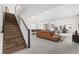 Open basement living area with staircase, pool table and comfortable seating at 7392 Timberstone St, Castle Pines, CO 80108