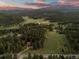 Breathtaking aerial view showcasing a home amidst a lush forest, with distant mountains in the background at 8821 Blue Creek Rd, Evergreen, CO 80439