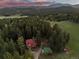 Stunning aerial view of a property surrounded by lush forest and mountain views at 8821 Blue Creek Rd, Evergreen, CO 80439