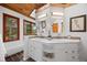 Bright bathroom with dual sinks, natural wood trim, and under cabinet storage at 8821 Blue Creek Rd, Evergreen, CO 80439