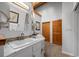 Bright bathroom featuring double sinks, white cabinetry, warm lighting, and decorative accents at 8821 Blue Creek Rd, Evergreen, CO 80439