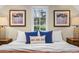 Close-up of bedroom featuring a bed with blue pillows, side tables, and artwork at 8821 Blue Creek Rd, Evergreen, CO 80439